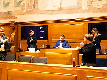 Im Anschluss an die Schlussrede des Stadtratspräsidenten Tom Berger erheben sich die Zuhörenden im Saal zum Applaus