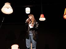 Stadtratspräsidentin Valentina Achermann steht auf der Bühnen, hält ein Mikro in der Hand und hält eine Rede.