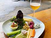 Teller mit Gemüse, Käse und weiteren Speisen. Dazu ein Glas Apfelsaft.