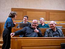 Stadtrat Niklaus Mürner blickt in Kamera und hält lächend den Daumen hoch. Neben ihm sitzt Bernhard Hess, dahinter sind Janosch Weyermann und Ueli Jaisli im Gespräch mit Tanja Miljanovic zu sehen.